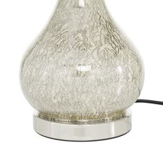 a glass table lamp with a metal base and an electric cord plugged into it