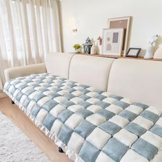 a living room with a checkered couch and white rug