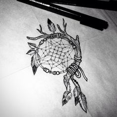 a drawing of a dream catcher with feathers and arrows on paper next to a marker