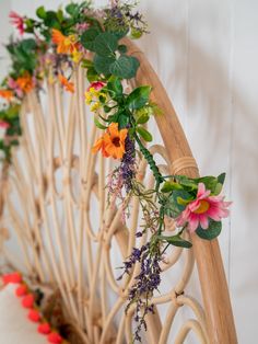 flowers are growing on the side of a wooden railing with vines and leaves attached to it