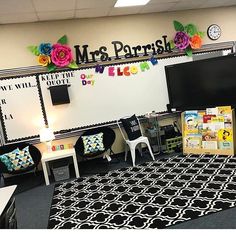 this classroom is decorated with black and white rugs, colorful decorations, and flowers