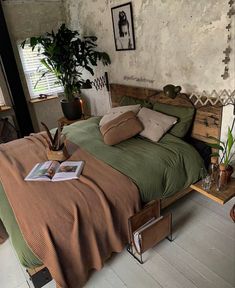 a bedroom with a bed, plant and pictures on the wall