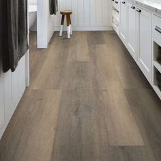 a kitchen with white cabinets and wood floors