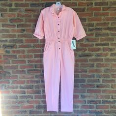 "NWT VTG 80s DREAMS Large jumpsuit overalls mechanic boiler suit snaps women's LABEL: Dreams SIZE: LARGE FABRIC: 100% Cotton (fabric has no stretch) CONDITION: GREAT CONDITION- with original tags attached COLOR: PINK Measurements: measured flat across - in inches  bust- 21\" Waist-resting-14\" Hips-22\" leg inseam-26\" Sleeve length-16\" shoulders across-20\" shoulder to crotch (from top of back of neck)-30\" overall length-56\" AMAZING FIND! NEW WITH TAGS! Vintage Pink Jumpsuit from the 1980's Retro Jumpsuits And Rompers With Pockets, Retro Short Sleeve Jumpsuits And Rompers With Pockets, Retro Jumpsuits And Rompers With Pockets And Relaxed Fit, Retro Relaxed Fit Jumpsuits And Rompers With Pockets, Spring Retro Overalls Jumpsuits And Rompers, Vintage Short Sleeve Jumpsuits And Rompers For Spring, Vintage Denim Jumpsuit For Work, Vintage Overall Jumpsuits And Rompers, Vintage Jumpsuits And Rompers With Pockets For Spring