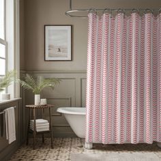 a bathroom with a bathtub, sink and shower curtain in pink colors on the wall