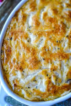 a casserole dish with cheese and herbs in it