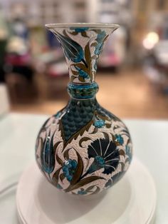 a blue and white vase sitting on top of a table