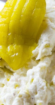 a yellow pickle sitting on top of some white cream and custard toppings