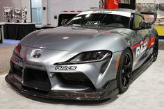 a silver sports car on display at an auto show