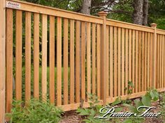 a wooden fence in front of some trees