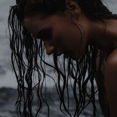 a woman with wet hair standing in the water