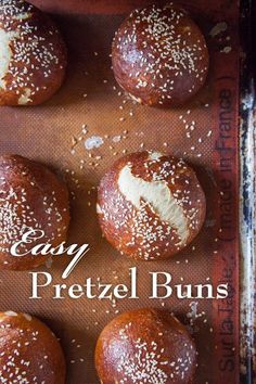 baked pretzel buns on a baking sheet with the words easy pretzel buns