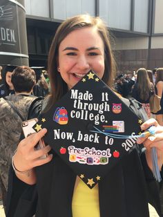 a woman holding up a graduation cap that says made it through college now, back to school