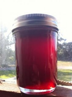 a jar filled with liquid sitting on top of a window sill