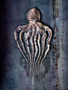 an octopus is hanging upside down on the side of a metal wall with rusted paint