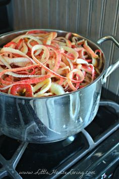 a pot filled with onions sitting on top of a stove next to a burner