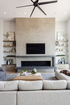 a living room with couches and a tv mounted on the wall above a fireplace