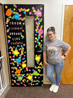 a woman standing in front of a door that says throw kindness around like confetti