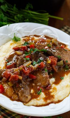 a white plate topped with mashed potatoes and meat