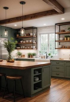 a large kitchen with green cabinets and wooden floors is pictured in this image, there are two stools at the center of the island