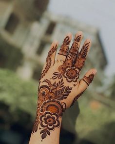 a woman's hand with henna tattoos on it