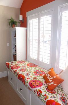 a room with a window seat and white shutters