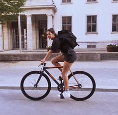 a woman riding a bike down the street