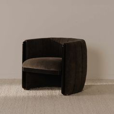 a brown chair sitting on top of a carpeted floor next to a white wall