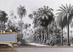 a wall with palm trees on it in front of a wooden cabinet and sideboard