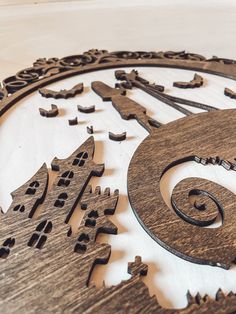 a wooden clock with many different designs on it's face and numbers in the middle