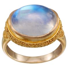 A blue flashing 10 x14 rainbow moonstone cabochon is set horizontally like a magical eye in a sightly cupped bezel surrounding by fine "pasir" sandlike granulation in this hand fabricated beauty from one oof our master artisanal goldsmiths. A wonderful juxtaposition of sheens and textures. Whoever ends up with this one will be happy! Currently sized 6.5. Resizable. Strengthen Intuition, 22k Gold Ring, Sapphire Cocktail Ring, Modern Bracelets, Gold For Sale, Gold Cocktail Ring, Blue Moonstone, Rainbow Moonstone Ring, Large Ring