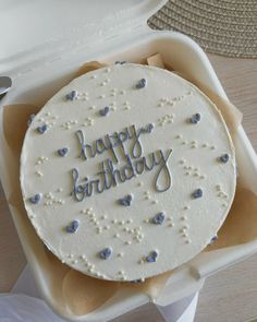 a birthday cake sitting in a box on top of a table