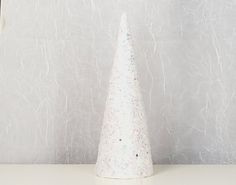 a small white christmas tree sitting on top of a table