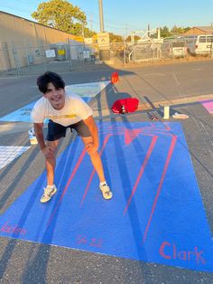 a person on a skateboard in the middle of a parking lot with chalk written on it