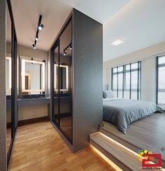 a bedroom with wooden floors and large mirrors on the wall next to it's bed