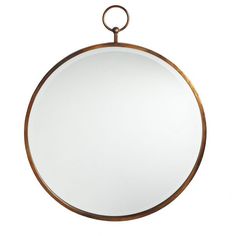 a round mirror hanging on the wall with a metal ring around it's edge