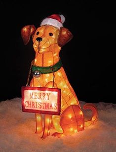 a lighted dog with a merry christmas sign on it's chest sitting in the snow