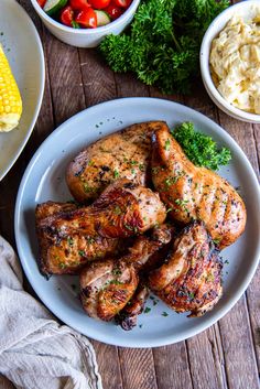 grilled chicken and vegetables on a plate next to a bowl of mashed potatoes