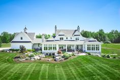 a large white house sitting on top of a lush green field