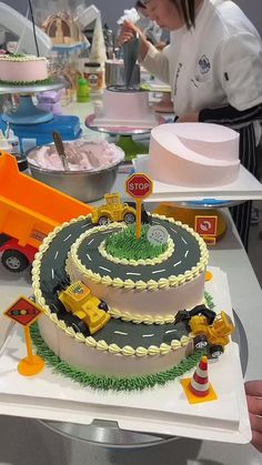 there is a cake that looks like a construction truck on the table with people around it