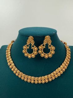 This exquisite piece of craftsmanship comes from our Traditional collection. Finish: 24 grams gold finish Necklace Fastening: Adjustable Dori Earring Fastening: Push Back Contains: 1 necklace, 1 pair of earrings Gold Metal Jewelry For Marriage, Gold Metal Jewelry For Wedding, Elegant Gold Bridal Necklace For Wedding, Elegant Gold Kundan Necklace Made Of Brass, Elegant Gold Kundan Necklace In Brass, Elegant Gold Jewelry Sets For Marriage, Elegant Chandbali Bridal Necklace In Brass, Gold Necklaces With Elegant Design For Anniversary, Elegant Brass Jewelry Sets For Festivals