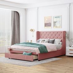 a bedroom with a pink bed and white walls, hardwood flooring and large windows