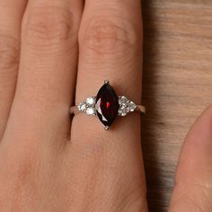 It is a natural garnet ring. The main stone is 7mm*12mm marquise cut, weight about 2.25 carats. The basic metal is sterling silver and plated with rhodium. To change the metal to a solid gold (white/rose) or platinum is also available, please ask for a quotation if you want. You can also go to my shop Home for more elegant rings: https://www.etsy.com/shop/godjewelry?ref=hdr_shop_menu More garnet rings: https://www.etsy.com/shop/godjewelry?section_id=20709242 Customization is always welcome and p Marquise Ruby Birthstone Ring, Silver Marquise Ruby Ring, Silver Marquise Cut Ruby Ring, Silver Marquise Ruby Ring As Gift, Silver Ruby Ring With Marquise Cut, Silver Marquise Cut Ruby Jewelry, Silver Marquise Ruby Ring For Anniversary, Marquise Cut Ruby Ring In Silver, Marquise Ruby Ring With Accent Stones For Anniversary