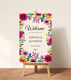 the welcome sign is on an easel in front of a white wall and wooden floor