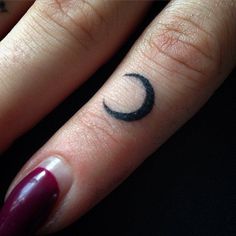 a woman's finger with a crescent tattoo on it