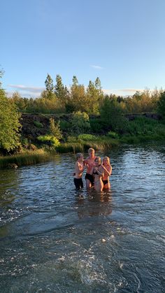 four people are standing in the water together