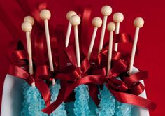 there are some cake pops on top of each other with red ribbons and bows around them