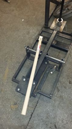 a baseball bat laying on the ground next to a metal rack with two bats in it