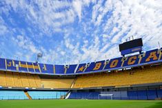 an empty stadium with blue and yellow seats under a partly cloudy sky stock images, sports pictures, football field, person, outdoor decor, royalty photos, architecture, scenery, travel