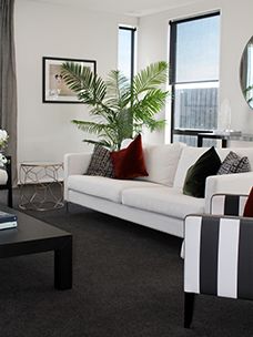 a living room filled with white furniture and lots of window sill space in front of it